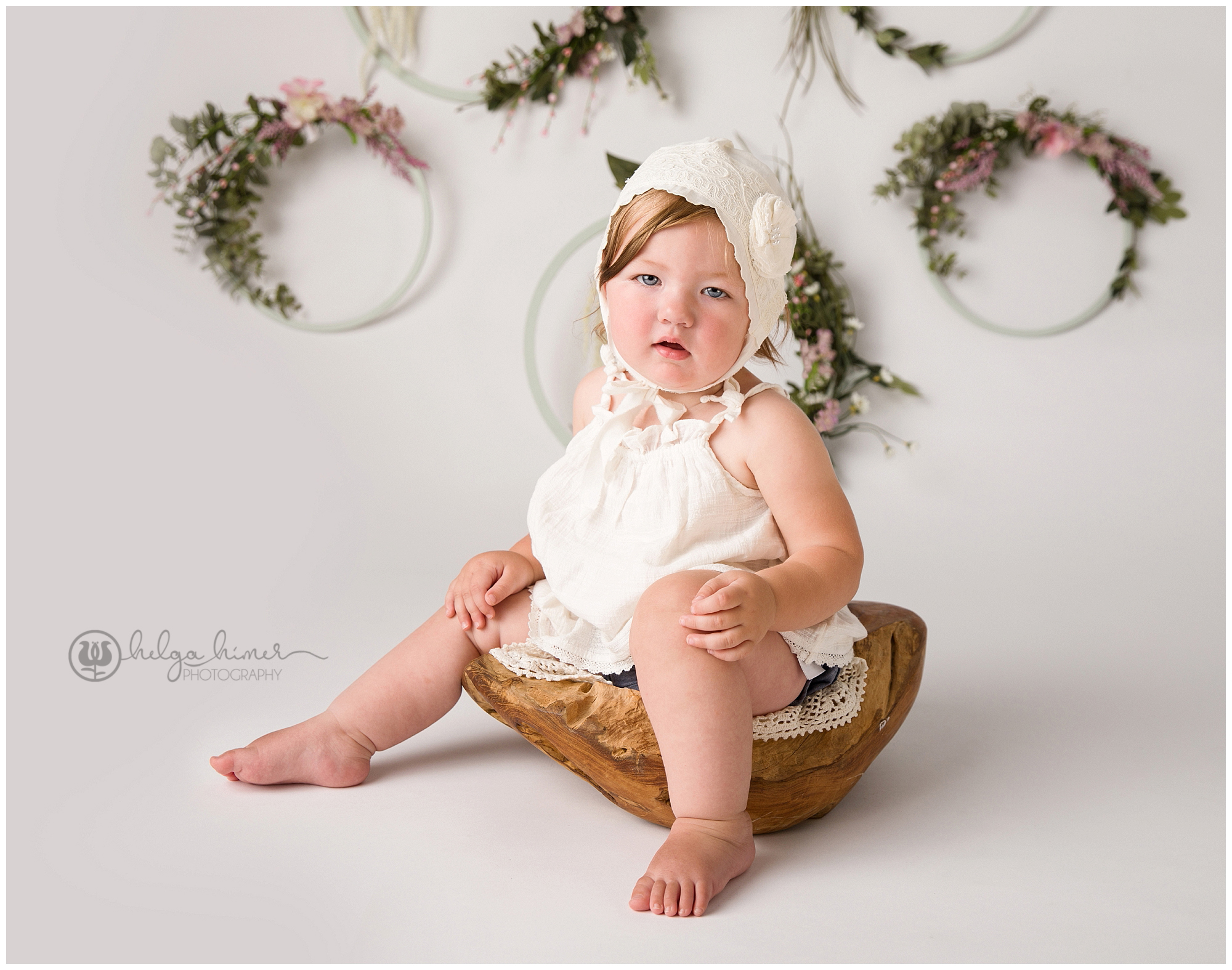 boho styled baby photoshoot. child sitting in a wooden bowl